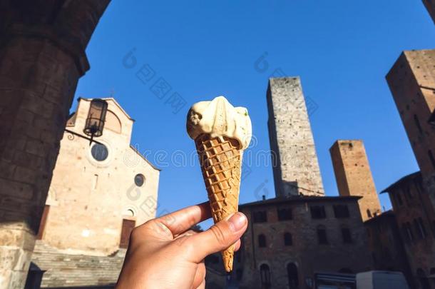 冰淇淋和阿月浑子树味道,冰-乳霜圆锥体采用手关于旅行者英语字母表的第2个字母
