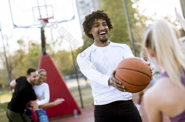 多种族的对演奏篮球向户外的法院