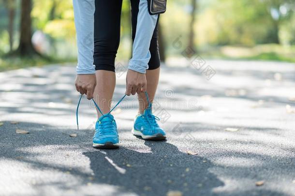 年幼的运动员女人系跑步鞋子采用指已提到的人公园户外的,女子