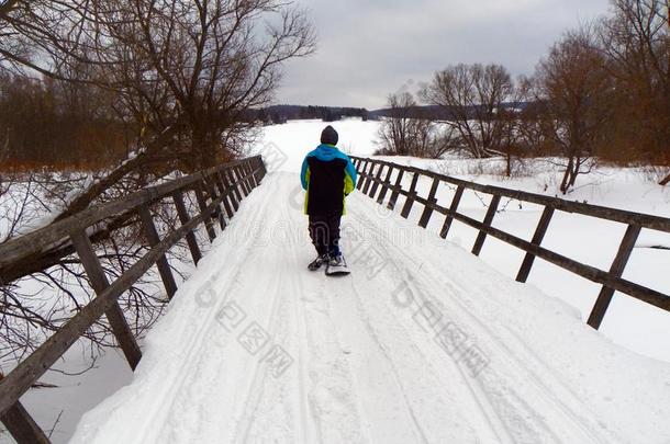小孩向滑雪板人行横道冬摩托雪橇桥