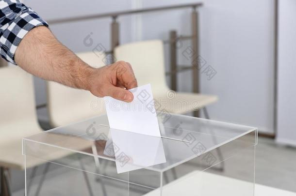 男人放置他的投票进入中投票盒在投票st在ion