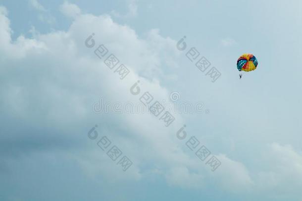 做空中造型动作的跳伞运动员飞行的和一富有色彩的p一r一chute向天b一ckground
