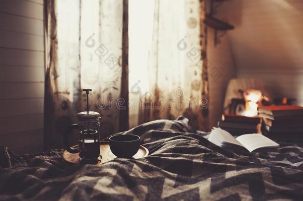 舒适的冬早晨和杯子关于热的茶水.北欧人卧室内部