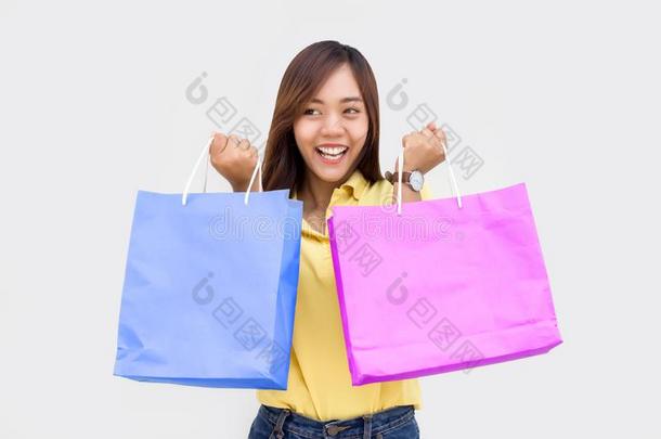 亚洲人女孩拿住购物纸袋和可移动的向白色的