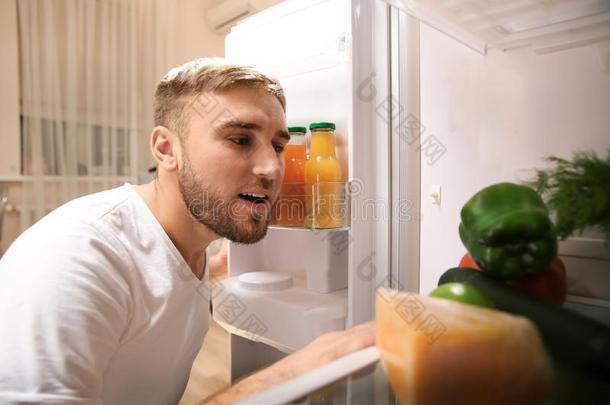 年幼的男人挑选食物采用冰箱