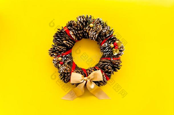 圣诞节花环使关于松树圆锥细胞向黄色的背景顶竞争