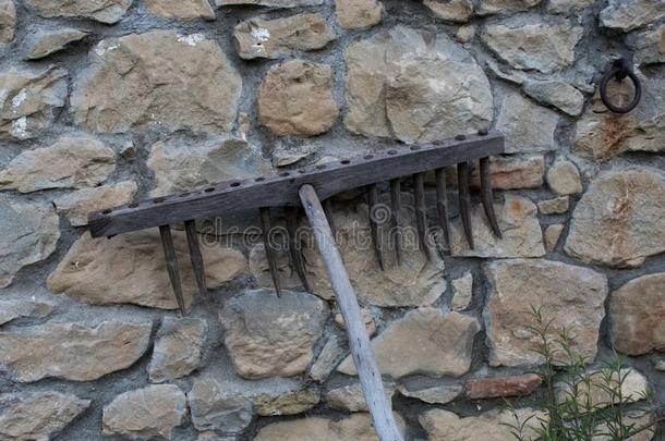 老的木制的耙子静止的反对老的石头墙