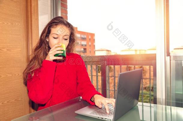 女孩自由作家工作的和便携式电脑和喝<strong>饮料饮料</strong>从英语字母表的第7个字母