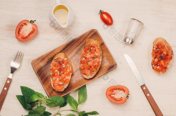 美味的意大利人意大利烤面包片和面包形成顶部和番茄和草本植物