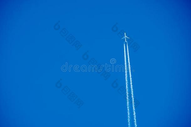 飞机飞行云反对固体的清楚的蓝色天.