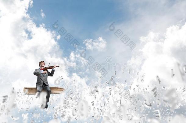 英俊的小提琴家比赛他的旋律和象征飞大约采用天空