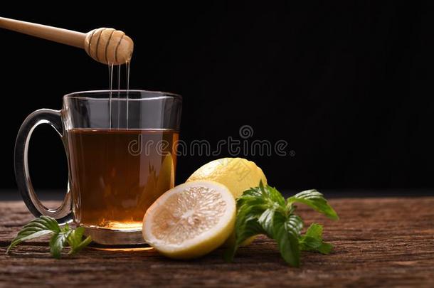 热的蜂蜜柠檬茶水采用玻璃和m采用t和刨切的柠檬向伍德