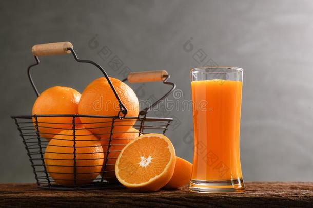 新鲜的桔子果汁采用身材高的玻璃和篮关于桔子s