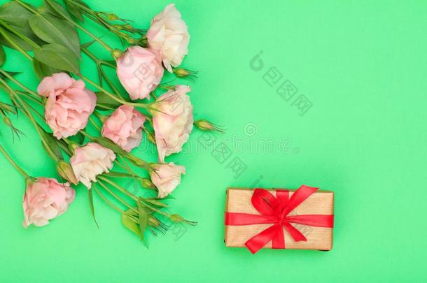 花束关于粉红色的花和树叶和赠品盒和红色的带