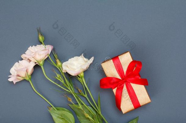 花束关于粉红色的花和树叶和赠品盒和红色的带