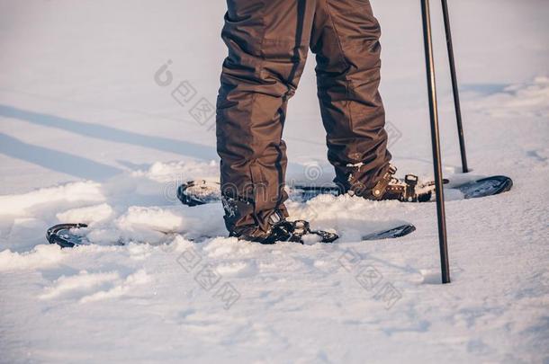 男人和雪鞋向指已提到的人雪小路关-在上面.男人采用雪鞋swinter冬天