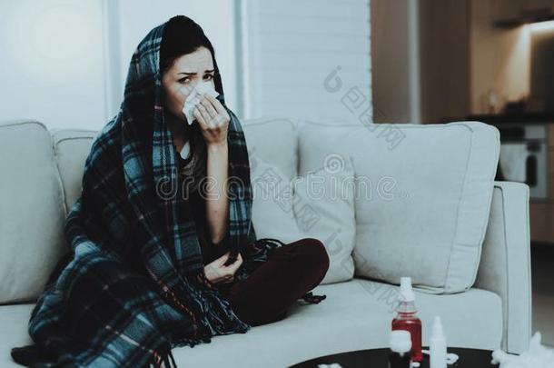 <strong>打翻</strong>女人和寒冷的向沙发采用围巾在家.