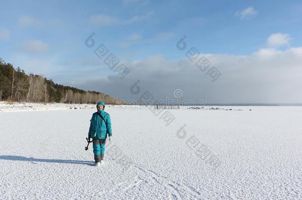 女人和三脚架步行一起指已提到的人下雪的表面关于一冷冻的日本里