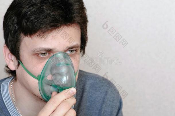 使用喷雾器和吸入器为指已提到的人治疗.年幼的男人吸入