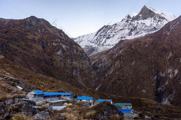 马查普查尔基础营地村民和顶部被雪所盖着的马查普查尔山峰