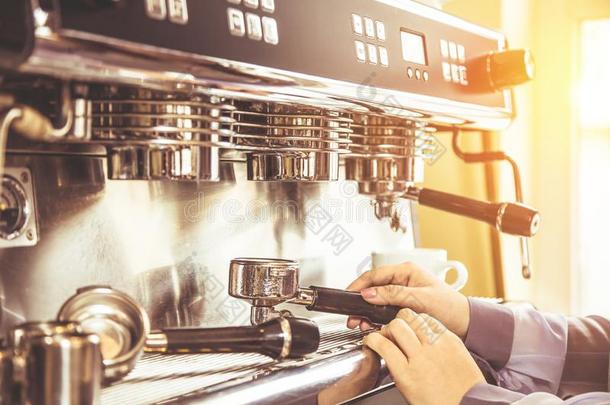 女人咖啡馆准备咖啡的员工使用咖啡豆机器为制造咖啡豆采用指已提到的人咖啡馆