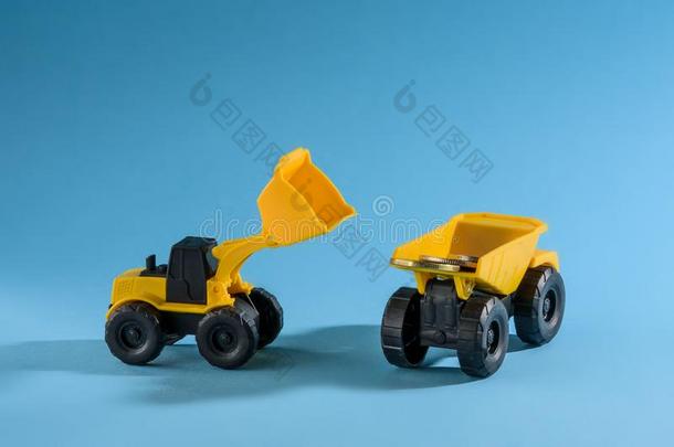 黄色的玩具货车和推土机装货coinsurance联合保险.空间为文本.