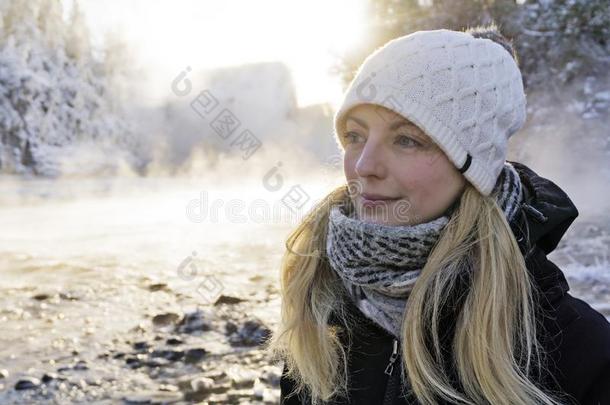 美丽的幸福的女人使人疲乏的冬帽子冬森林和水