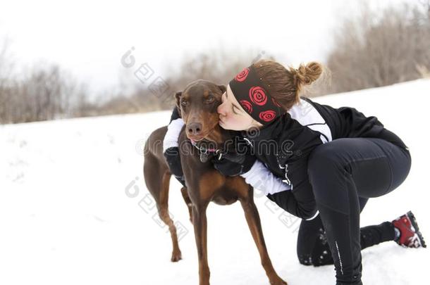 一美丽的女人和多伯曼短尾狗冬季节