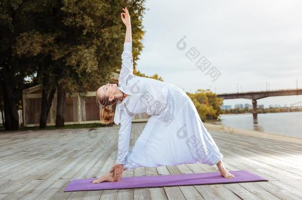 轻松的女人起立采用指已提到的人三角形瑜伽使摆姿势