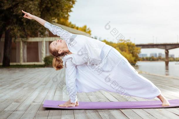 镇定的和确信的女人在从事职业的瑜伽使摆姿势户外的