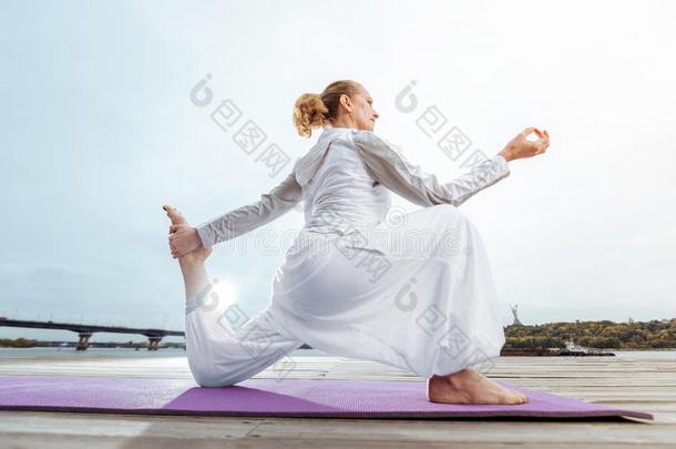 女人InmProving公司她健康状况在旁边在从事职业的早晨瑜伽