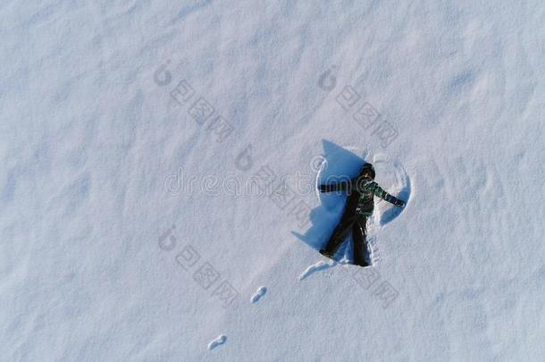 男孩关于7年使雪天使采用雪地区.空气的photograp照片.