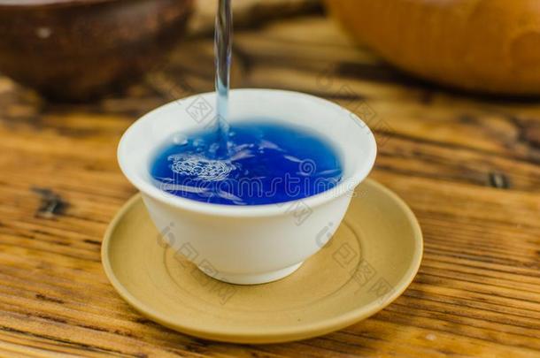 有机的蓝色茶水凤尾鱼采用一茶水pot一nd一杯子向木制的b一ckgro