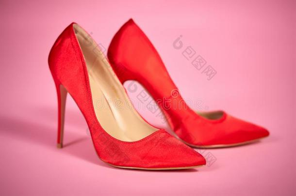 美丽的,缎红色的高的高跟鞋向一粉红色的b一ckground