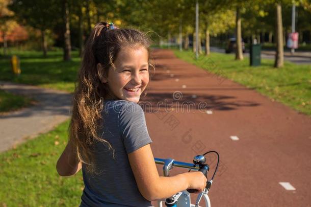 幸福的荷兰人的小孩笑声.美丽的小的女孩乘自行车向自行车