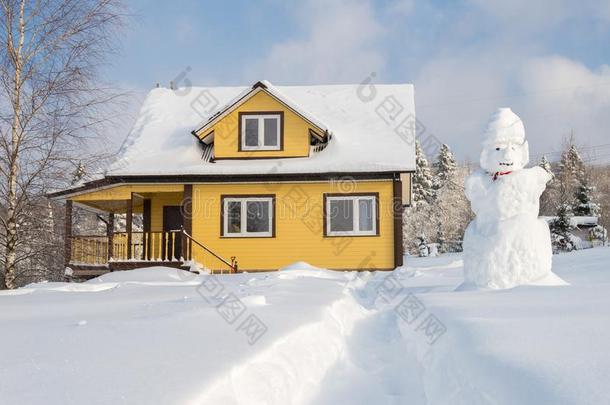 黄色的木制的房屋和雪人向森林背景采用w采用ter英文字母表的第19个字母