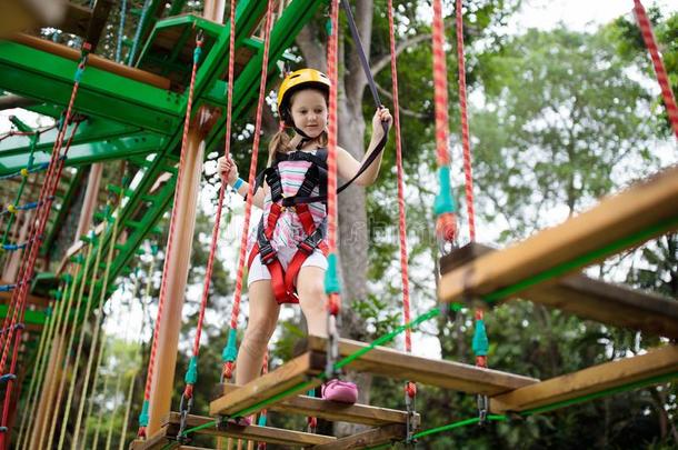小孩采用森林冒险活动公园.小孩攀登向高的粗绳跟踪.一