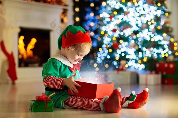 小孩开幕现在的在圣诞节树在家.小孩采用小精灵价钱