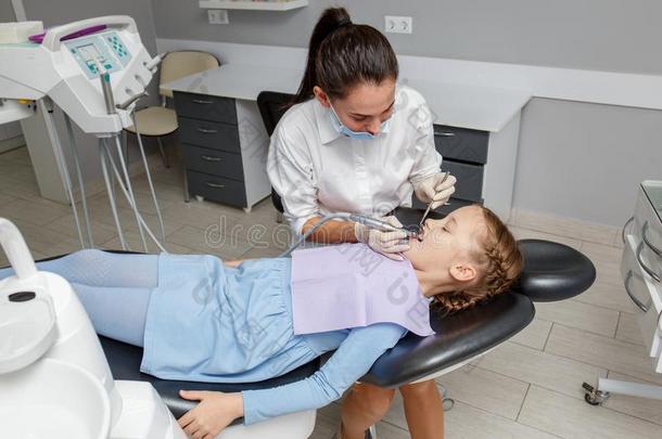 小孩女孩所有专业的牙齿的清洁采用牙科医生办公室