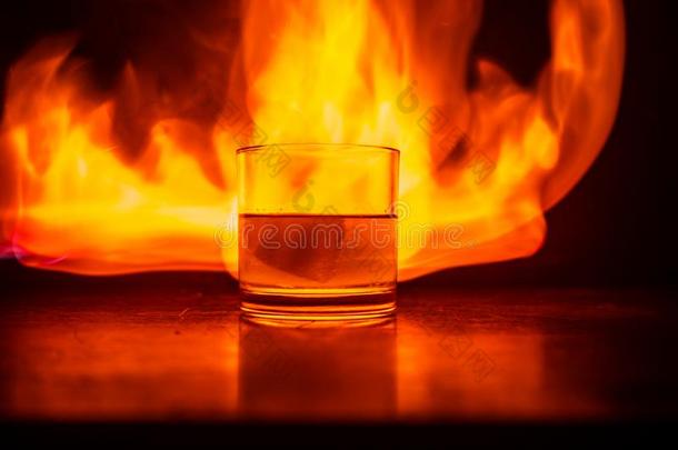 威士忌酒采用火观念.玻璃关于威士忌酒和冰向木制的海浪