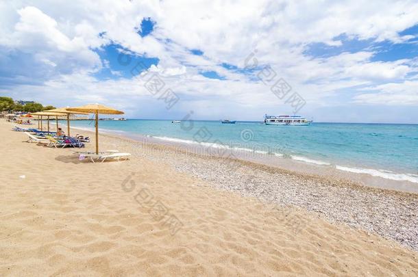 潮湿的大海海滩和遮阳篷,太阳灯浴浴床和小船采用背景希腊字母的第17字