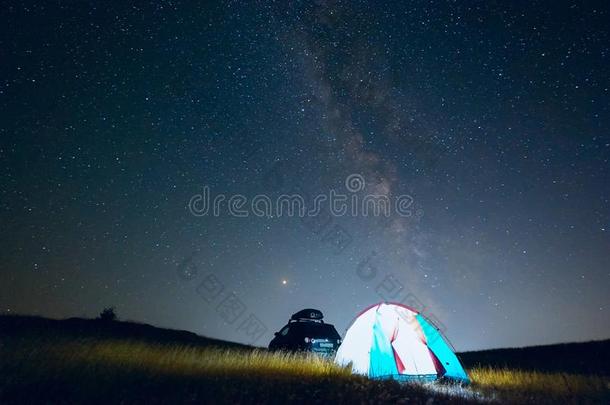 旅行者帐篷和汽车在夜向指已提到的人背景关于指已提到的人像牛奶的道路