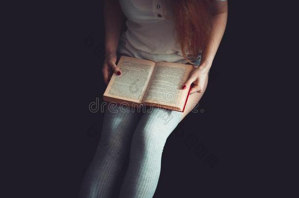 软的照片关于女人向指已提到的人床阅读书.女人采用膝上短袜