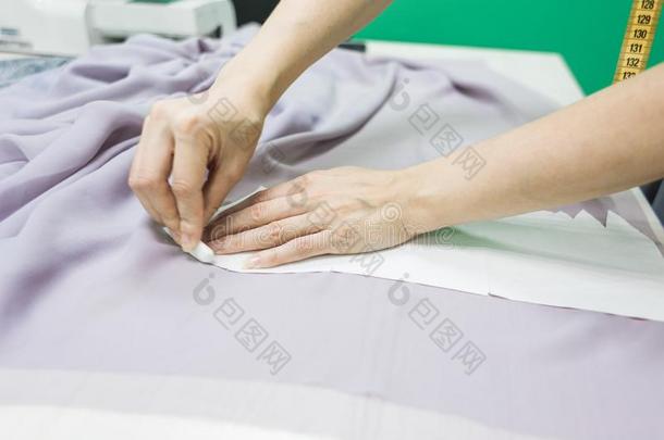 缝纫车间.女裁缝在使工作.标记和锋利的织物.