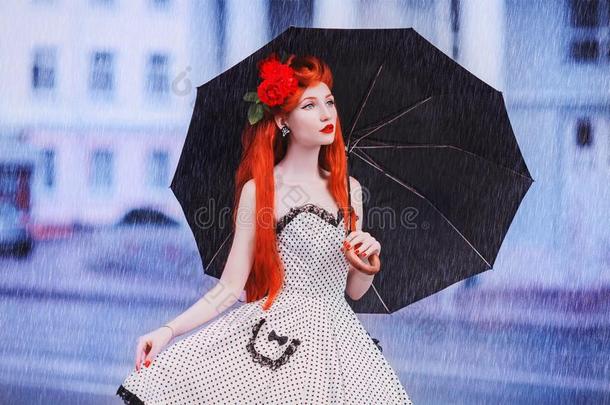 湿的天气.秋雨.孤独的女孩采用波尔卡舞点衣服拿住英语字母表的第2个字母