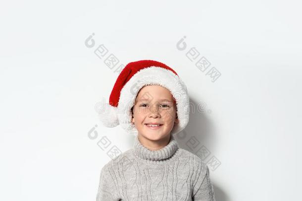 漂亮的小的男孩采用暖和的毛衣和圣诞节帽子