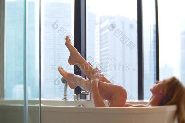 美丽的女人享有令人轻松的沐浴采用奢侈沐浴room和一