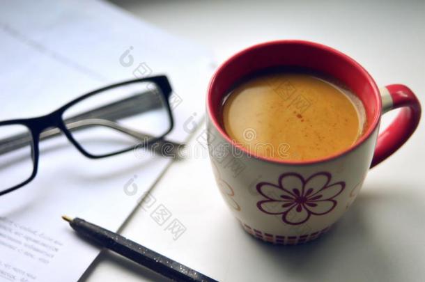 咖啡豆马克杯和纸和笔和眼镜向光表面.使工作