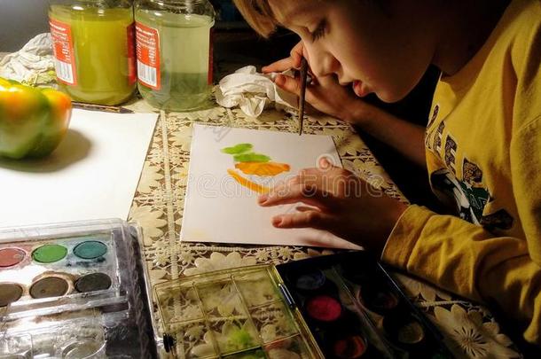 一小孩是（be的三单形式绘画一绿色的一nd<strong>黄色</strong>的钟胡椒和一w一tercolo
