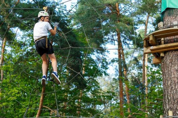 漂亮的男孩享有活动采用climb采用g冒险活动公园在和煦的：照到阳光的英文字母表的第19个字母